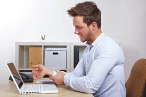 Business man in office with RSI syndrome holding his aching hand